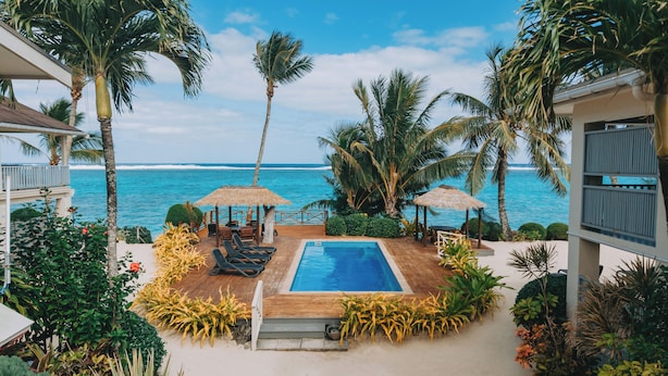 A pool area with lounge chairs, a small pool, and palm trees. - Moana Sands Villas & Apartments (Rarotonga)