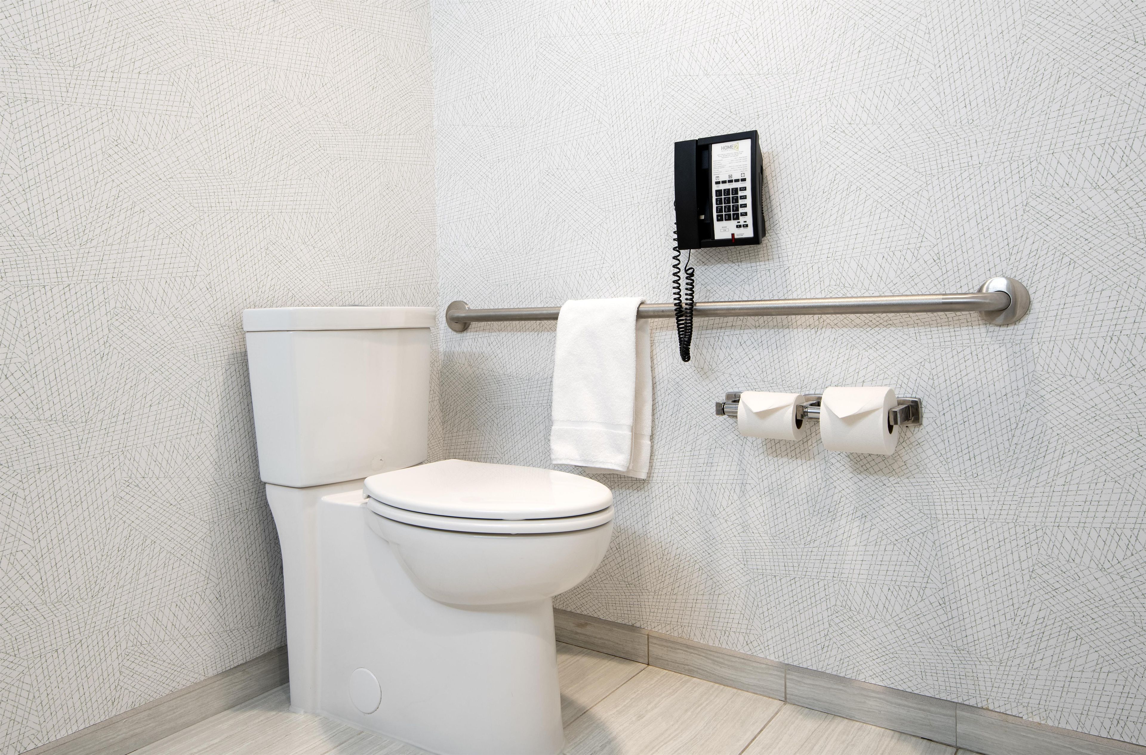 Un baño con inodoro, toallero y teléfono.