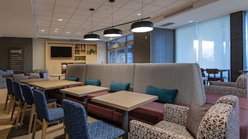 Un restaurant moderne avec des banquettes, des tables et des chaises à motifs.