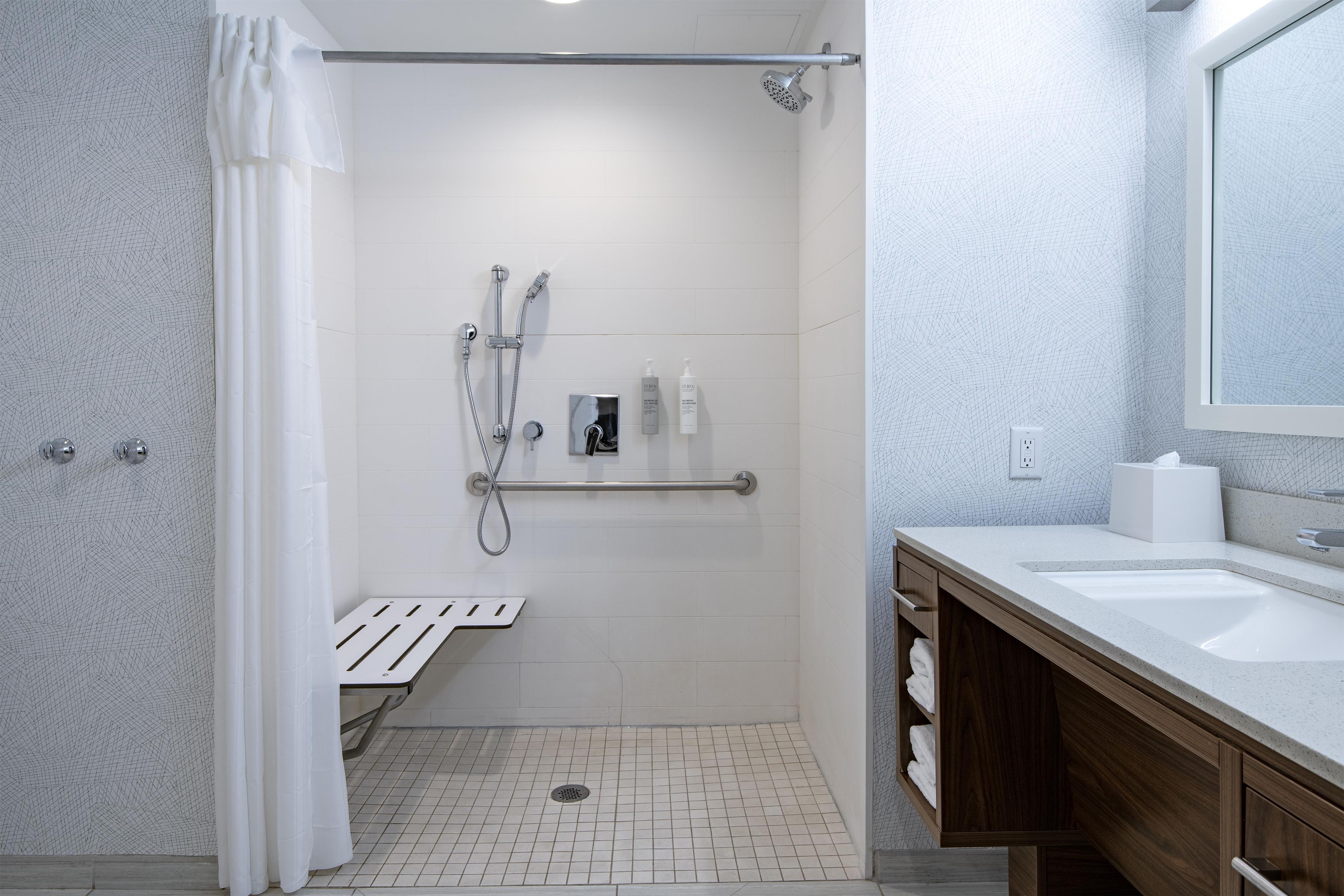 A modern bathroom with a shower, toilet, and sink.