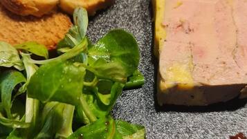 A plate with slices of bread, a piece of meat, and a green salad.