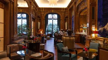 A luxurious lobby with ornate wood paneling, a bar area, and comfortable seating.