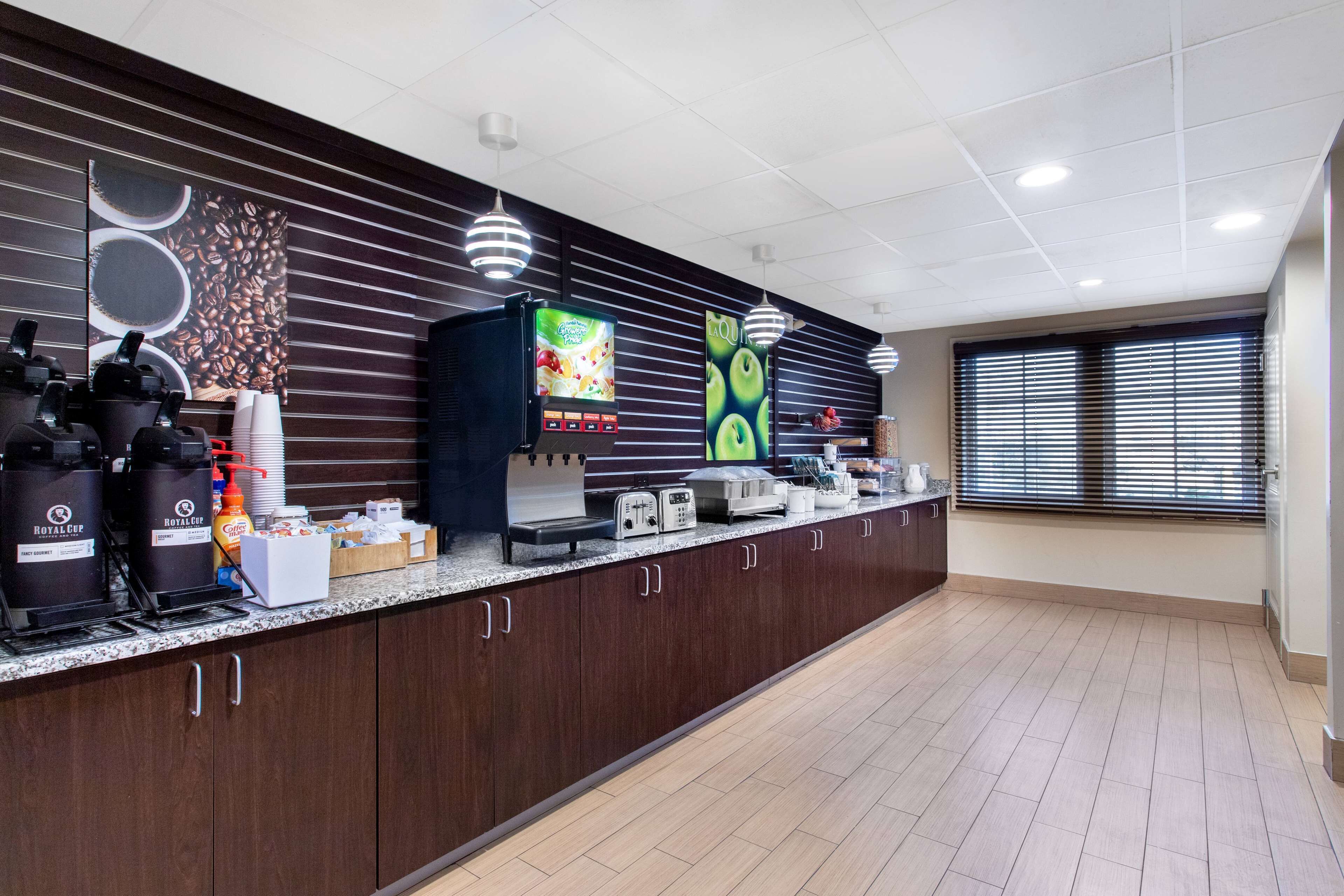 Un espace cuisine moderne comprenant un coin café, un distributeur de jus et un grille-pain.
