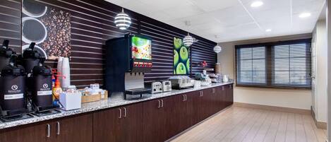 Un espace cuisine moderne comprenant un coin café, un distributeur de jus et un grille-pain.