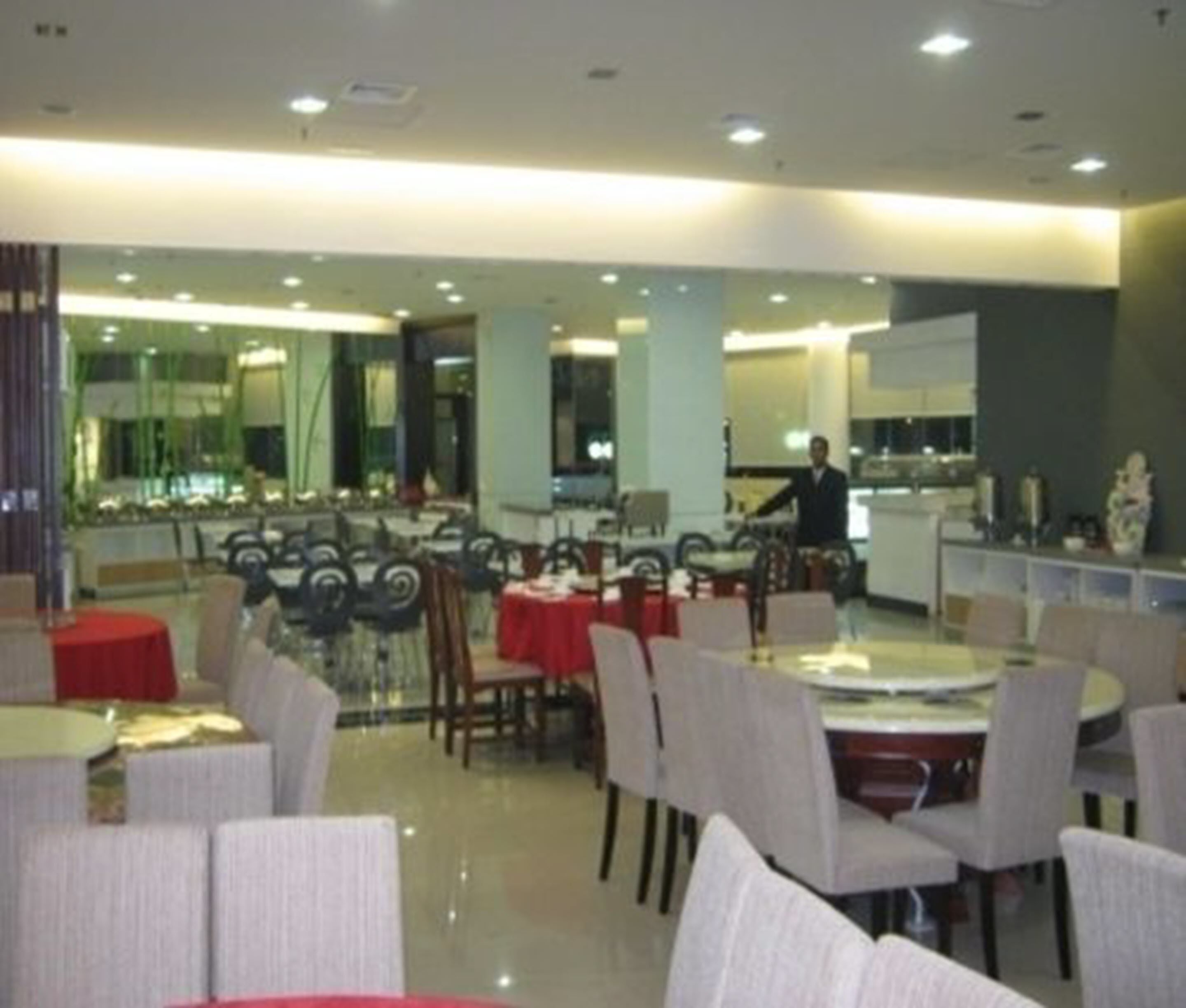 A restaurant with round tables and chairs, a bar area, and a counter.