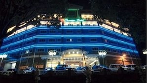 A multi-story hotel with a prominent entrance and a parking lot in front.