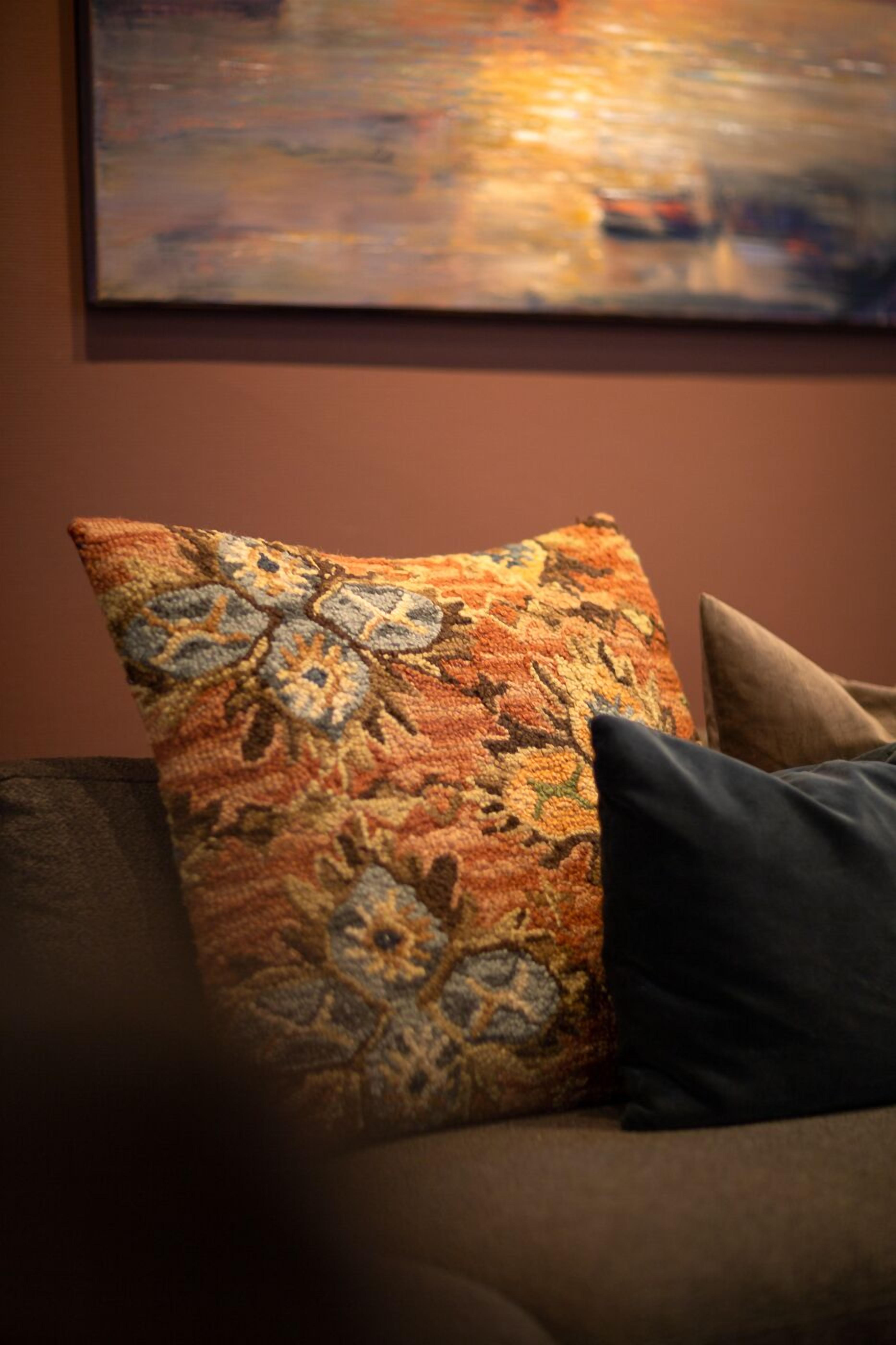 A couch with a patterned cushion and a plain cushion.