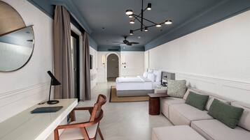 Una habitación de hotel moderna con cama, sofá, escritorio y silla.
