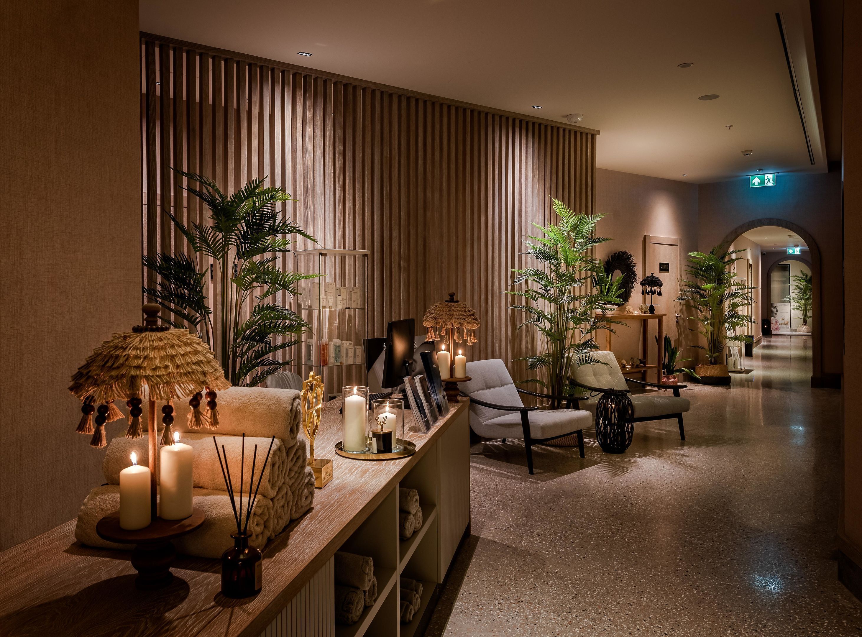 A lobby with a reception desk, seating area, and a corridor leading to other rooms.