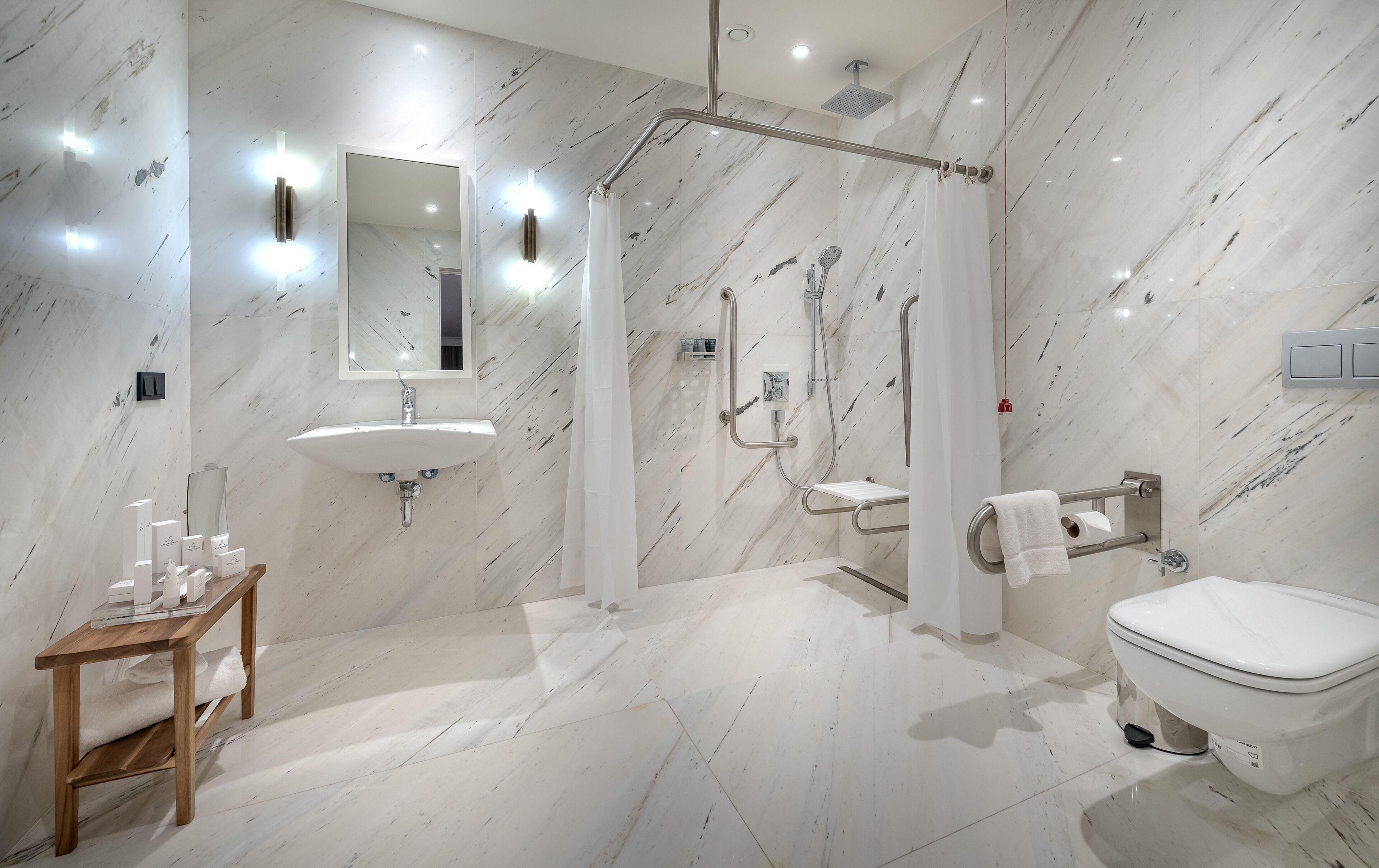 A modern bathroom with a marble floor, a sink, a toilet, and a shower area.