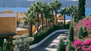 A landscaped pathway leading to a building with a view of the sea. - Casa Nonna Bodrum - Adult Only (Bodrum)