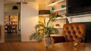 Un salon chaleureux avec un fauteuil en cuir, une table basse en bois et une plante en pot.