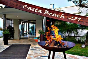Una fogata con llamas frente a un edificio identificado como "Casta Beach Z59".