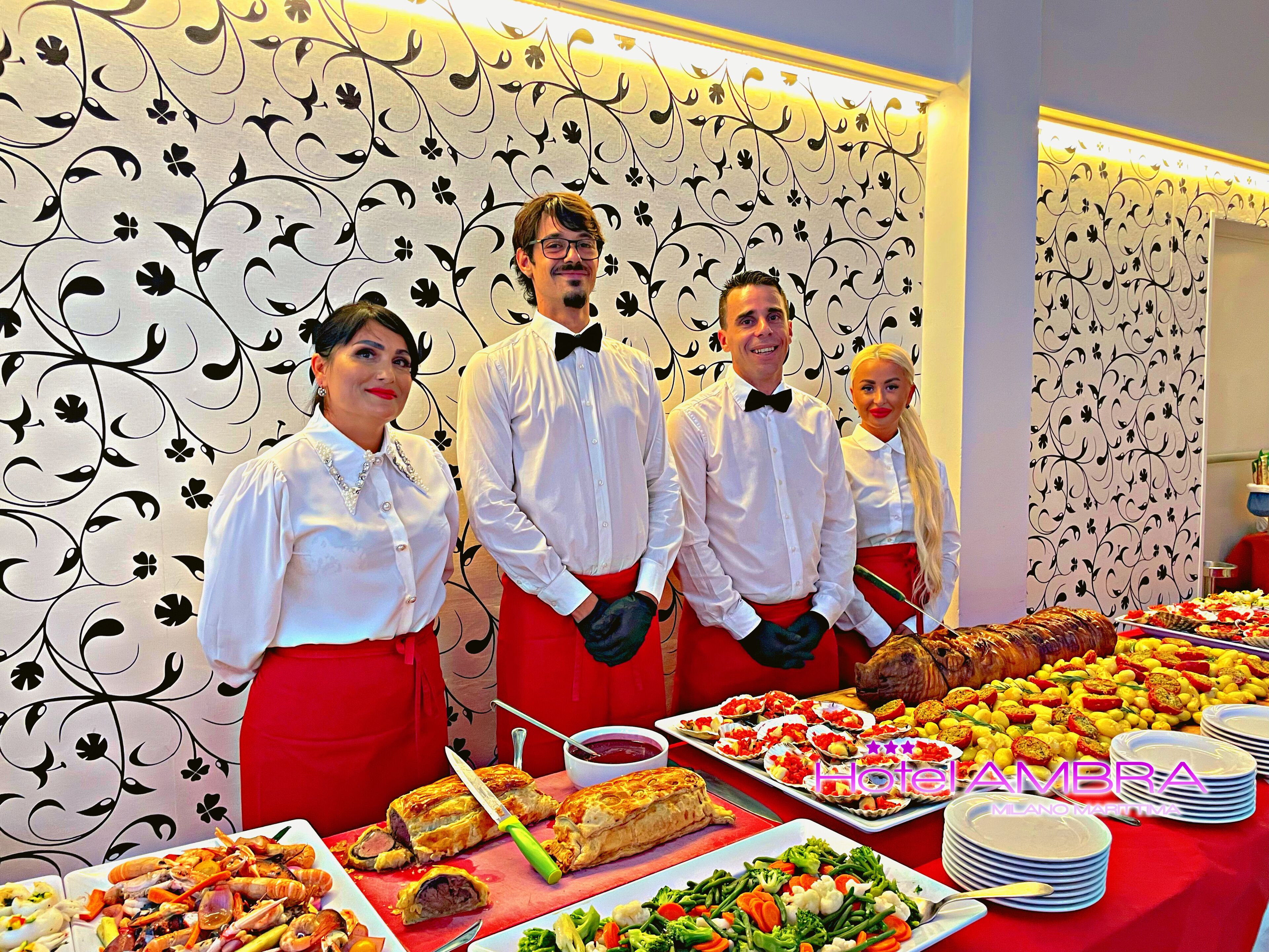 En buffet med forskellige retter, herunder fisk og skaldyr, kødpiroger og grøntsager.