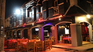 A restaurant with outdoor seating, wooden tables, and chairs. - Asia Blue The Tavern Hacienda - Hostel (Ko Pha-ngan)