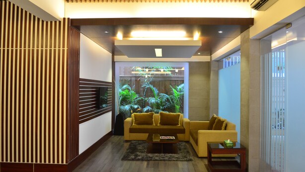 A modern living room with a sofa, a coffee table, and a decorative plant wall. - Hotel La Villa Western (Dhaka)