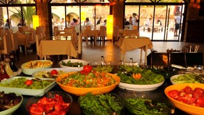 A buffet with various dishes, including salads and vegetables, in a dining area with tables and chairs. - The Grand Üçel Hotel (Fethiye)