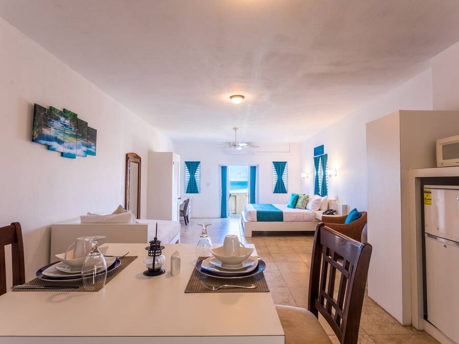 Una habitación de hotel moderna con comedor, sala de estar y cocina.