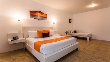 Una habitación de hotel moderna con una cama grande, una cama más pequeña, una mesita de noche con un teléfono y una obra de arte colgada en la pared.