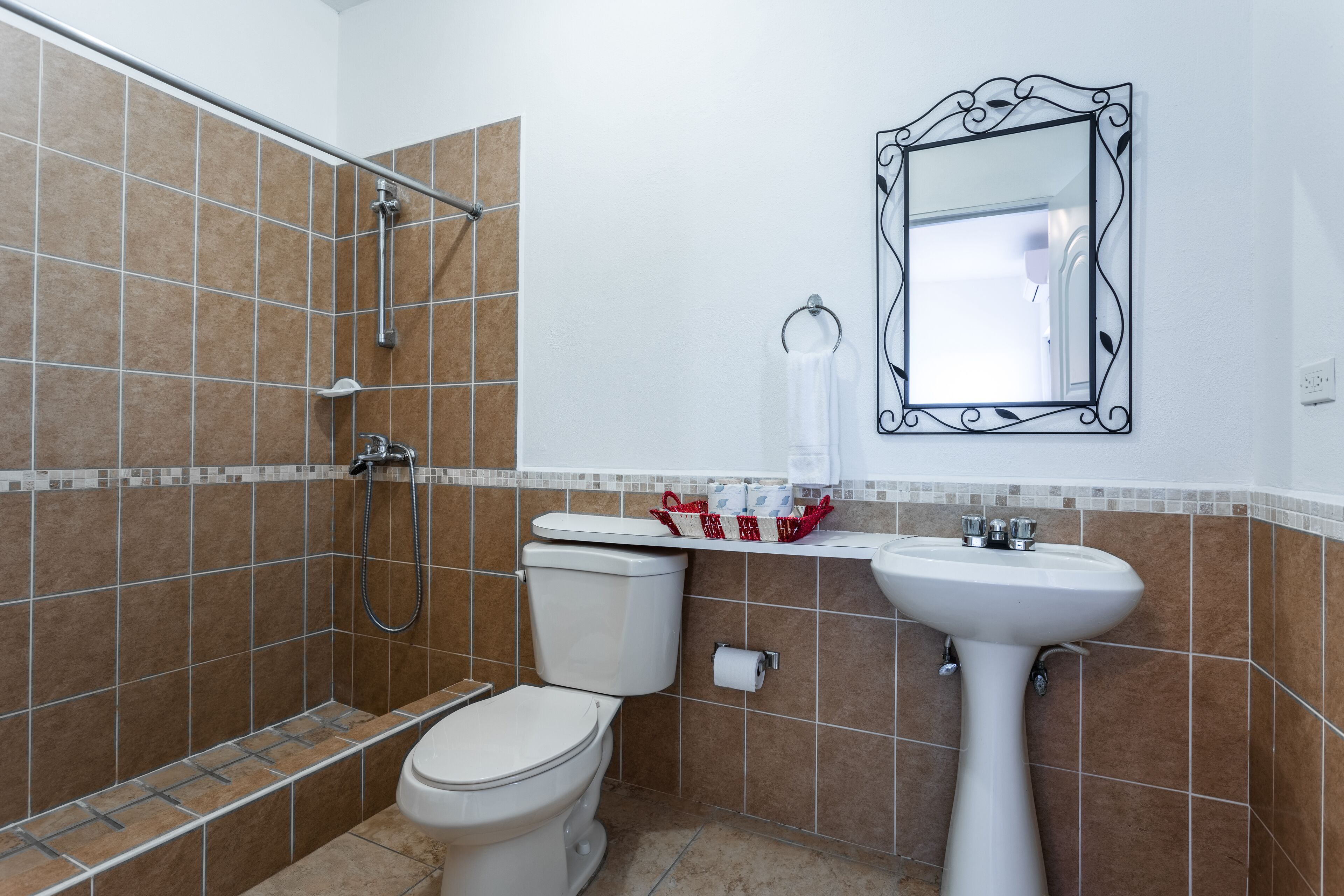 Une salle de bain avec des toilettes, un lavabo et une douche.