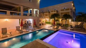 A swimming pool with lounge chairs and umbrellas, surrounded by a multi-story building with balconies. - La Vue Boutique Inn (South Hill)