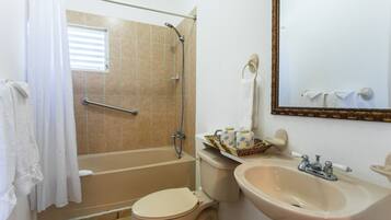 A bathroom with a bathtub, toilet, sink, and a mirror.