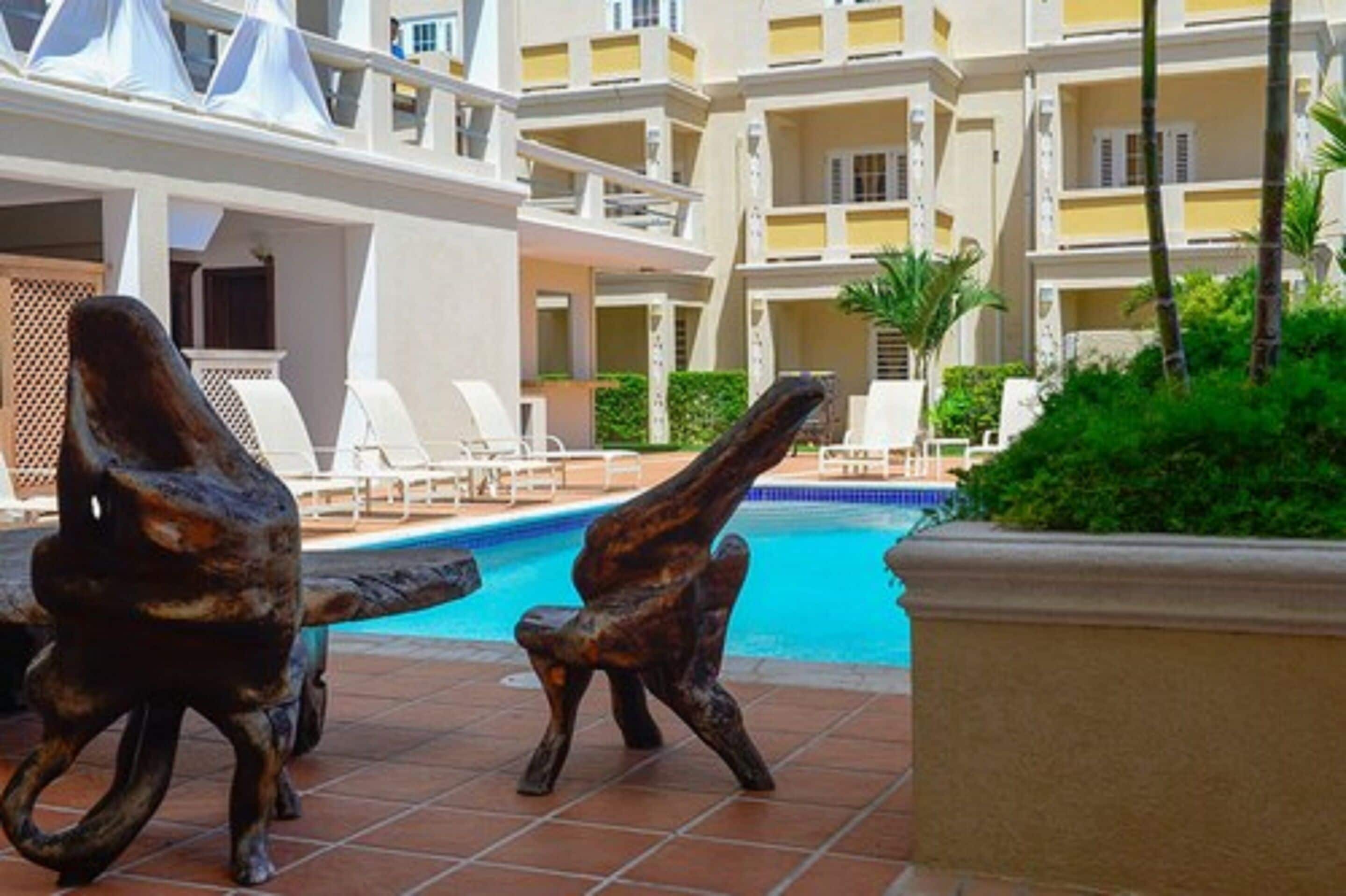 A pool area with lounge chairs and a decorative sculpture.
