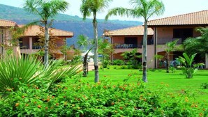 A hotel with multiple buildings, each featuring a tiled roof and surrounded by lush greenery and flowering plants. - TH Pizzo Calabro - Porto Ada Village (Pizzo)