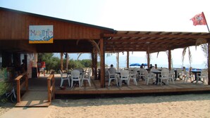 A beachside restaurant with outdoor seating and a view of the sea. - TH Pizzo Calabro - Porto Ada Village (Pizzo)