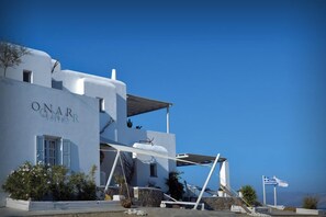 A modern white building with the name "ONAR" on the facade, featuring a prominent entrance and a clear view of the surrounding landscape.