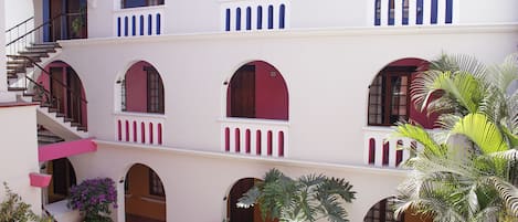A multi-level building with balconies, staircases, and potted plants.