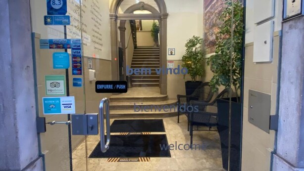 An entrance with a glass door, a staircase, and a welcome mat. - Estrela de Arganil (Lisbon)