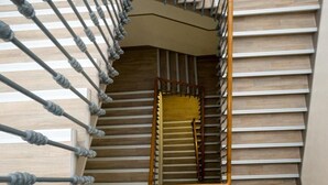 A spiral staircase with a wooden finish and a yellow handrail. - Estrela de Arganil (Lisbon)