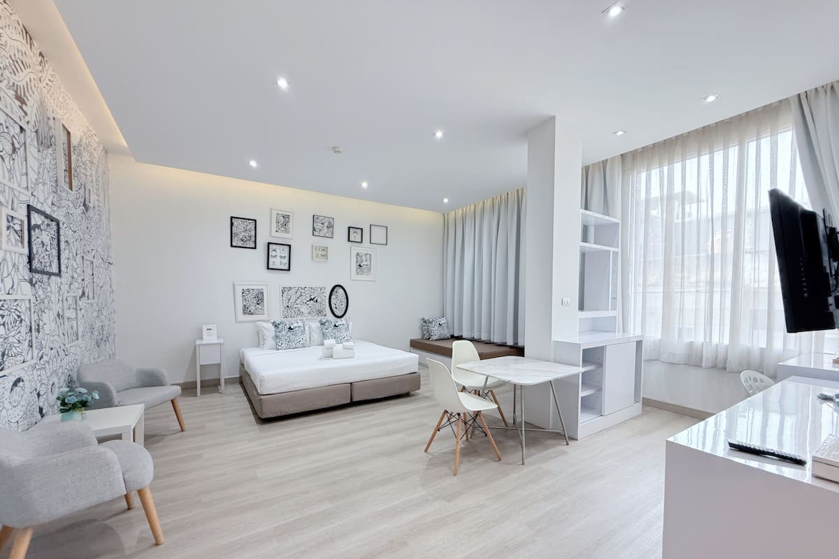 Une chambre à coucher moderne, équipée d’un lit, d’un bureau et d’une télévision.