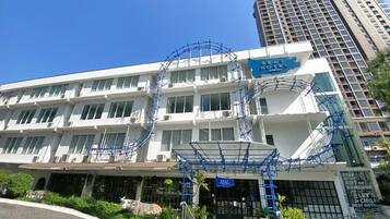 Un hôtel doté d’une façade moderne, de plusieurs étages et d’une enseigne bleue bien visible.