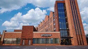 A hotel with a brick facade, large windows, and a sign reading "MANHUA AKTURA HOTEL".
