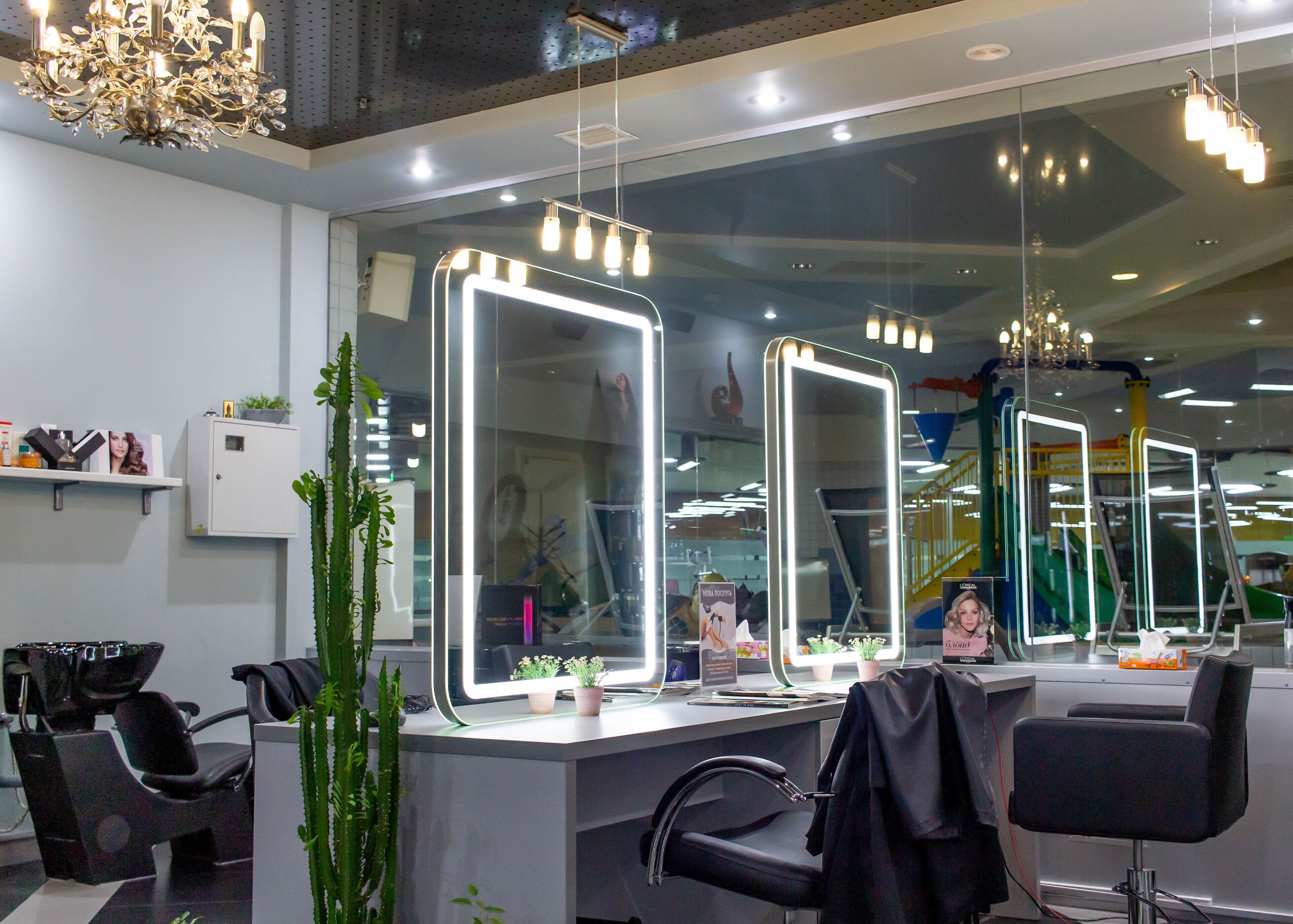 Un salón con múltiples espejos, sillas y un candelabro.