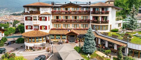 A hotel with multiple balconies, outdoor seating, and a view of the surrounding area.