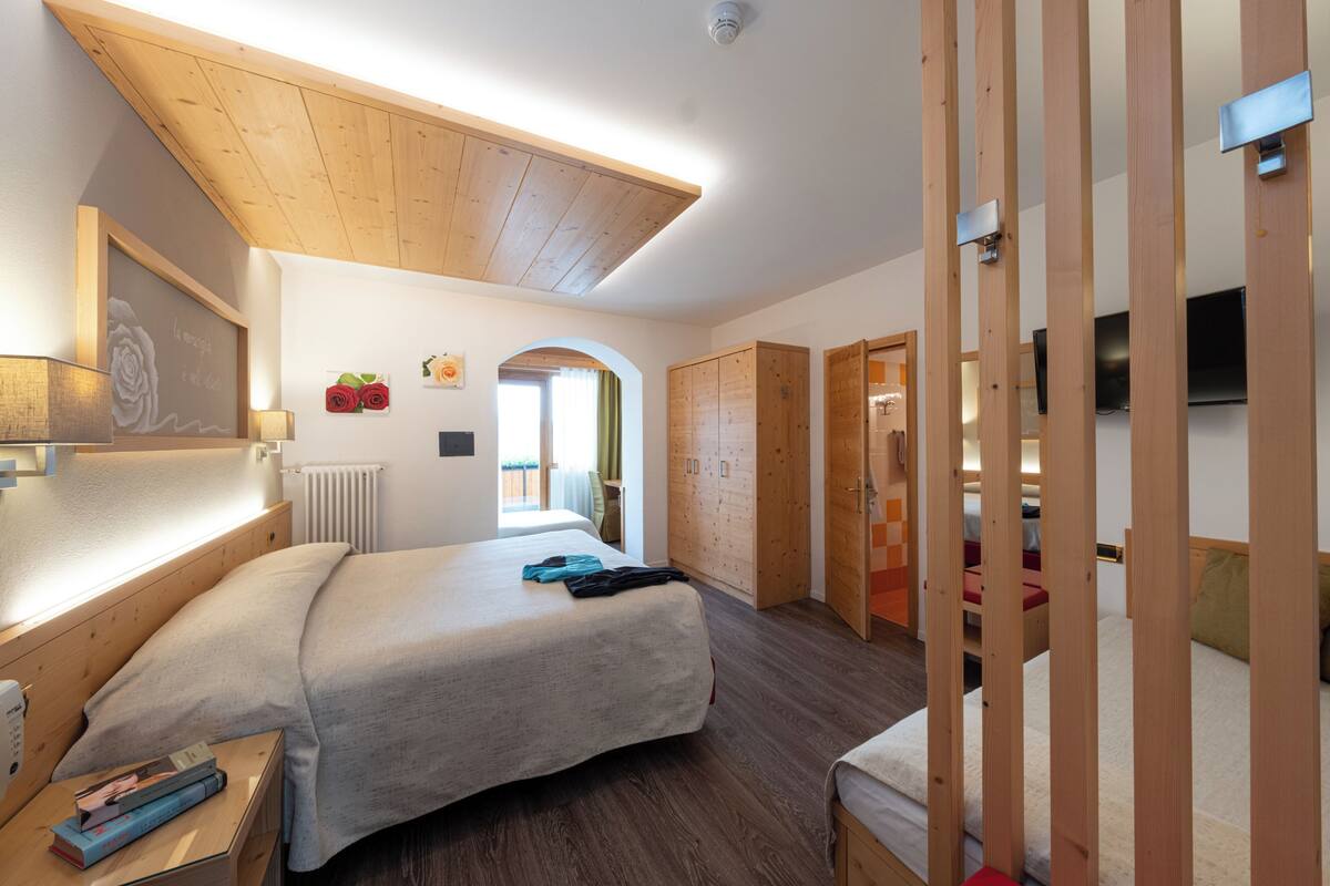 Une chambre à coucher avec un lit, un plafond en bois, une armoire et un téléviseur.