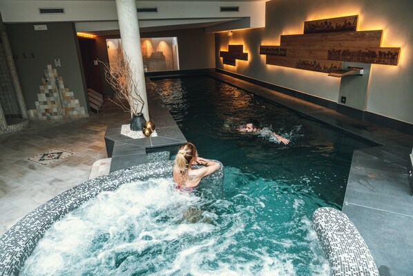 Een binnenzwembad en ligstoelen