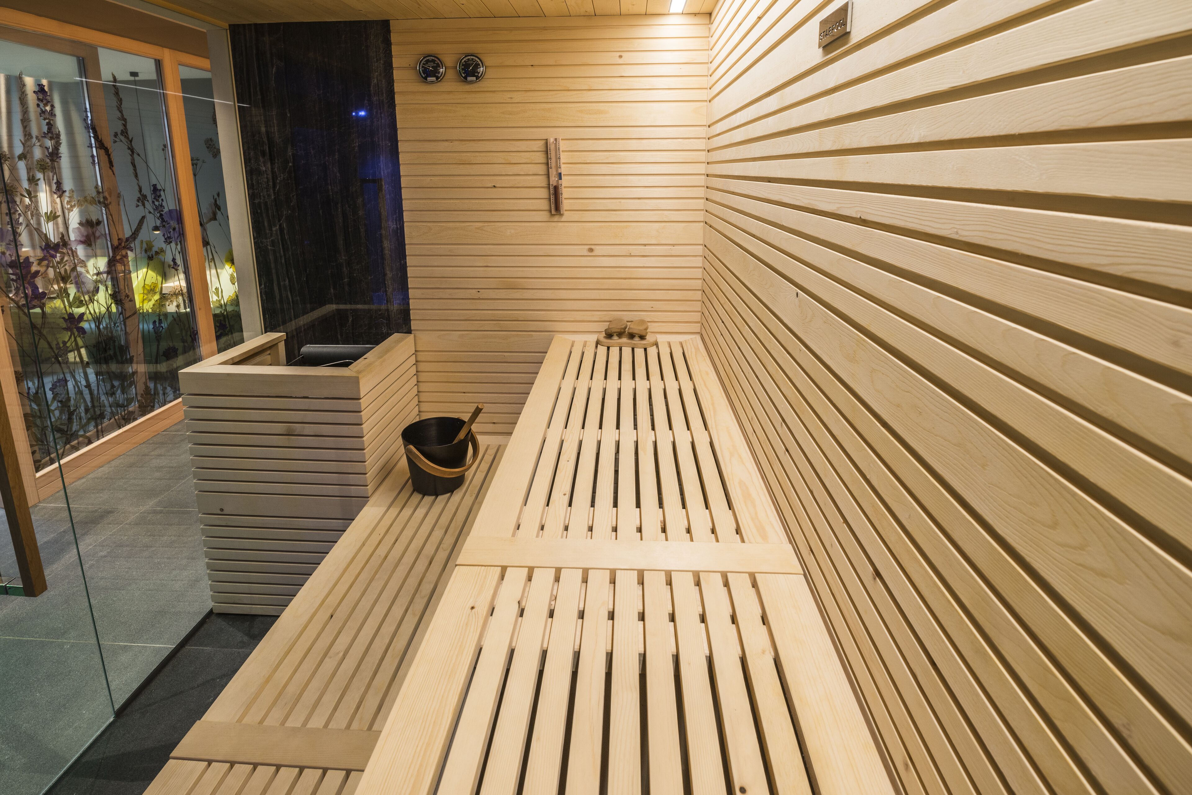 A sauna with wooden benches and a stone basin.