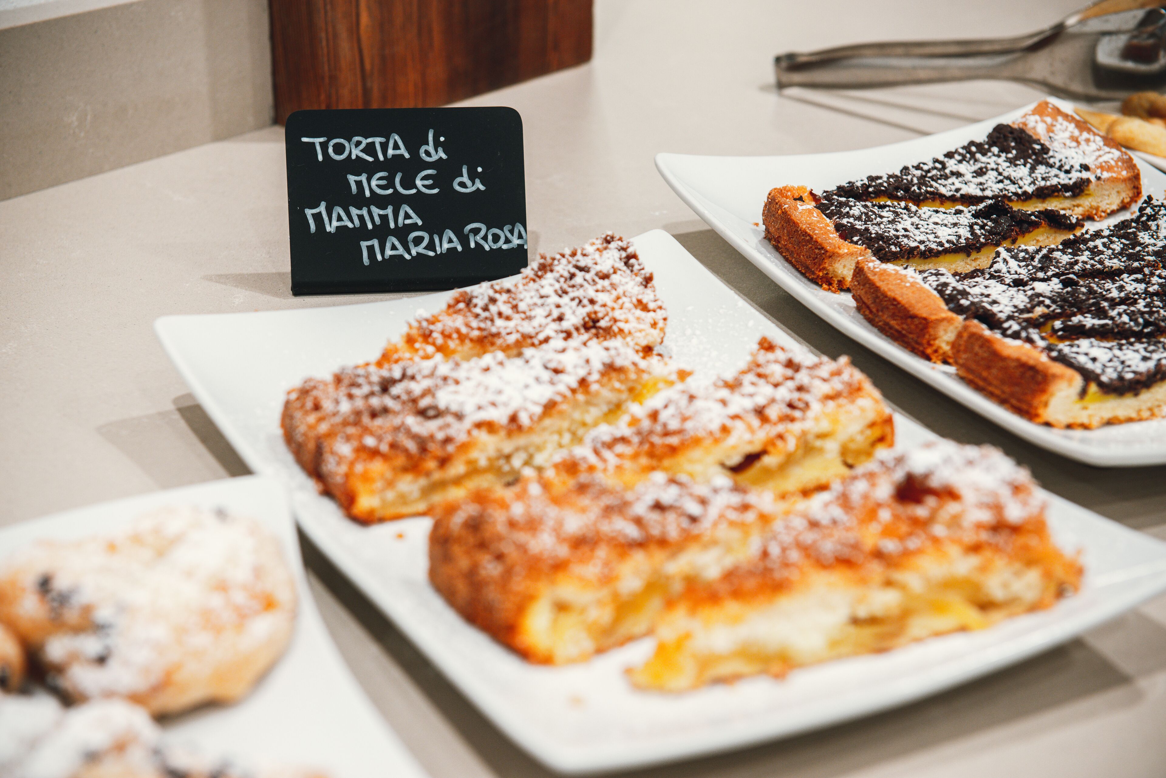 A dessert display with various pastries and a sign indicating a specific type of tart.