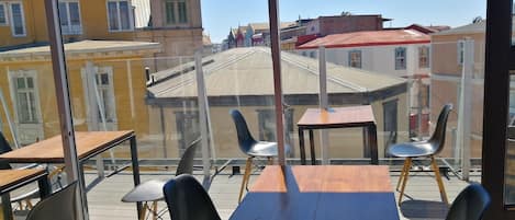 A dining area with tables and chairs, large windows offering a view of buildings and a tower.