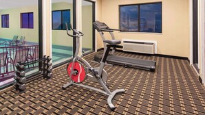 Une chambre d’hôtel équipée d’un tapis de course, d’un vélo d’exercice et d’haltères.