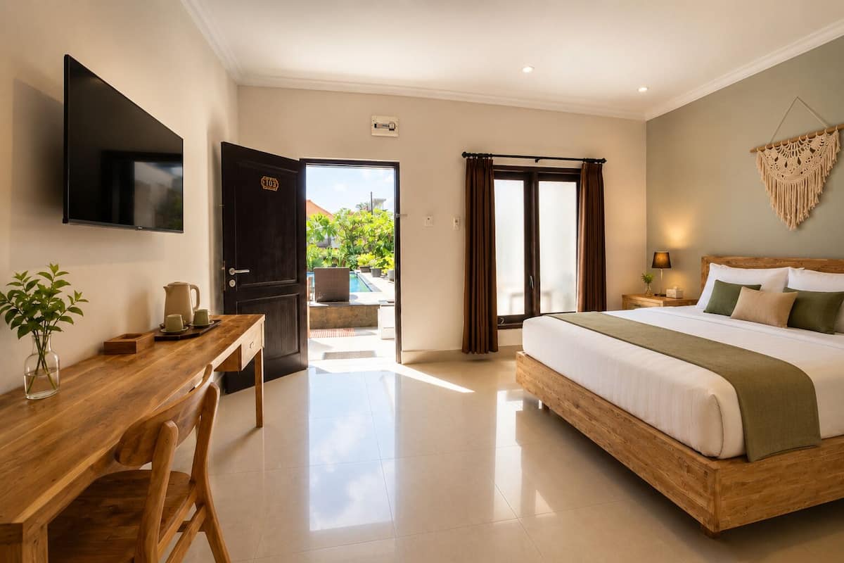 Une chambre d’hôtel équipée d’un lit, d’un bureau, d’une télévision et offrant une vue sur l’extérieur.