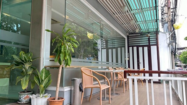 An outdoor seating area with wicker chairs and potted plants. - S3 Residence Park (Bangkok)