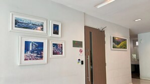 A hallway with framed cityscape pictures, a door labeled "3", and a "No Smoking" sign. - S3 Residence Park (Bangkok)