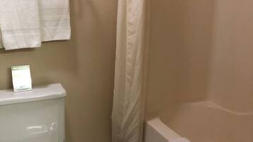 A bathroom with a toilet, a shower, and a towel rack.
