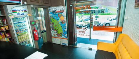 A reception area with a counter, a vending machine, a map, and a view of the street outside.