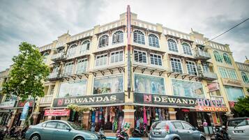A multi-story building with a prominent 'DEWANDAS' sign, indicating a textile center.